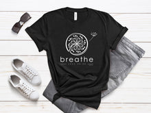 Load image into Gallery viewer, Faith-based Bella+Canvas t-shirt featuring an inspirational I Peter 5:7 design, encouraging you to cast your cares on God and breathe deeply in a chaotic world.&quot;
